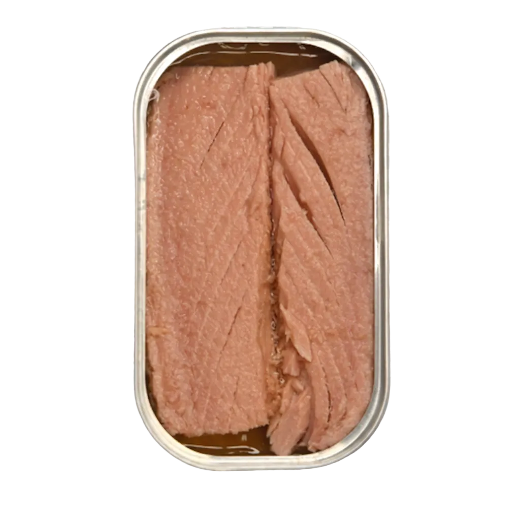 An open metal can of sliced pink fish, likely tuna, showing the flaky texture of the meat inside, isolated on a gray and white checkered transparency background.